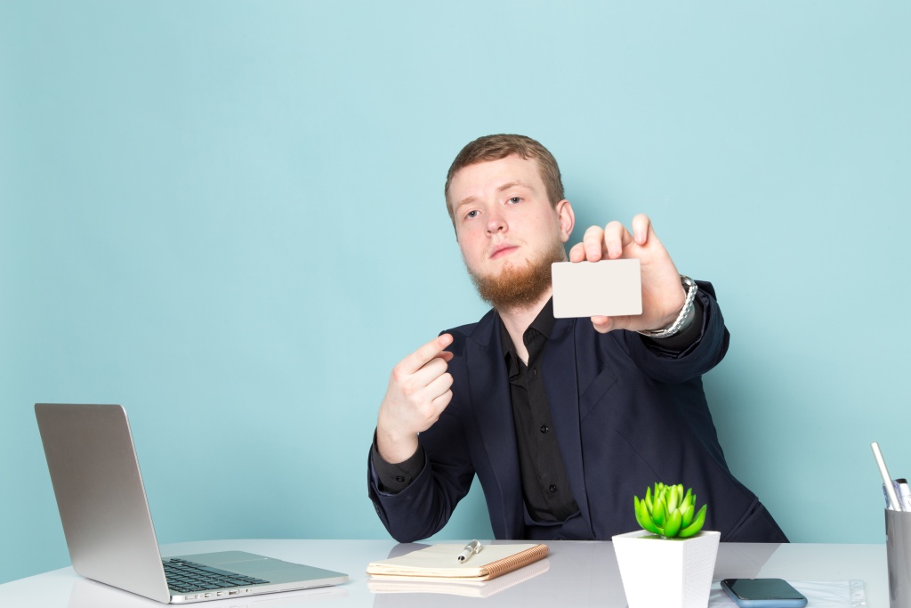front-view-young-attractive-male-with-beard-black-dark-classic-modern-suit-using-laptop-showing-white-card-blue-space.jpg мужчина